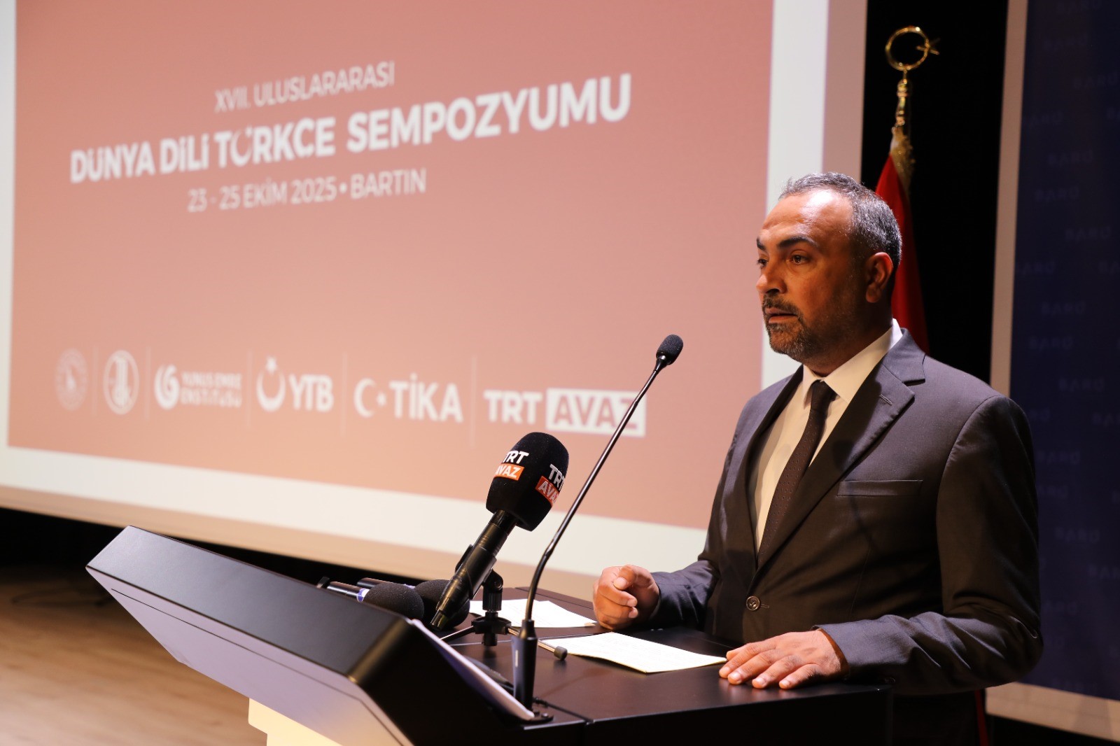 "Türkçeyi korumak ortak sorumluluğumuzdur"
Gösterinin ardından geçilen açılış konuşmalarında ilk olarak BARÜ Rektörü Prof. Dr. Ahmet Akkaya, Türkçenin evrensel değerini ve kültürel mirasını vurguladı. Rektör Akkaya, "Bizler bugün bir medeniyetin hafızasını, bir milletin ruhunu yansıtan Türkçemizi konuşmak üzere buradayız. Küreselleşen dünyada, diller arasındaki etkileşim kaçınılmazdır. Ancak bu etkileşim içinde Türkçenin özgün sesini, estetiğini ve düşünme biçimini korumak bizlerin ortak sorumluluğudur. Çünkü bir dili yaşatmak o dili sevgiyle, bilinçle ve üretkenlikle kullanan çocuklar yetiştirmek sayesinde olur. Bu da çocuklarımıza iyi bir eğitim vermekten geçer. Bugün sempozyum kapsamında sunulacak bilim insanlarının çalışmaları, Türkçemizi sadece korumakla kalmayacak dilimizi geleceğe taşımaya katkı sunacak." dedi.